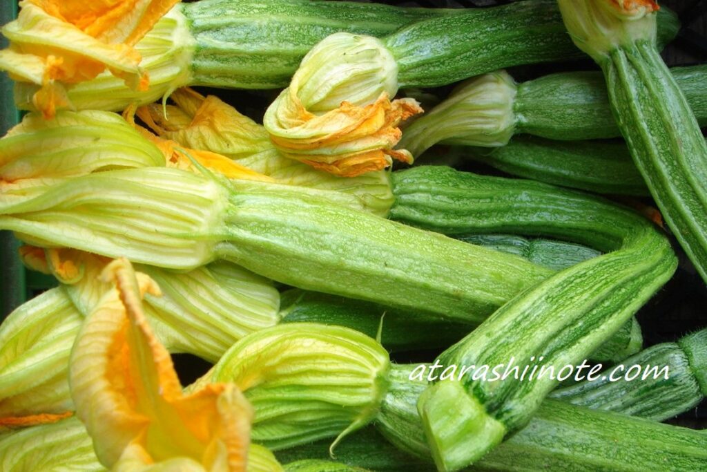 イタリアの夏に出回る花のついた黄緑色のズッキーニ、メルカート（市場）にて