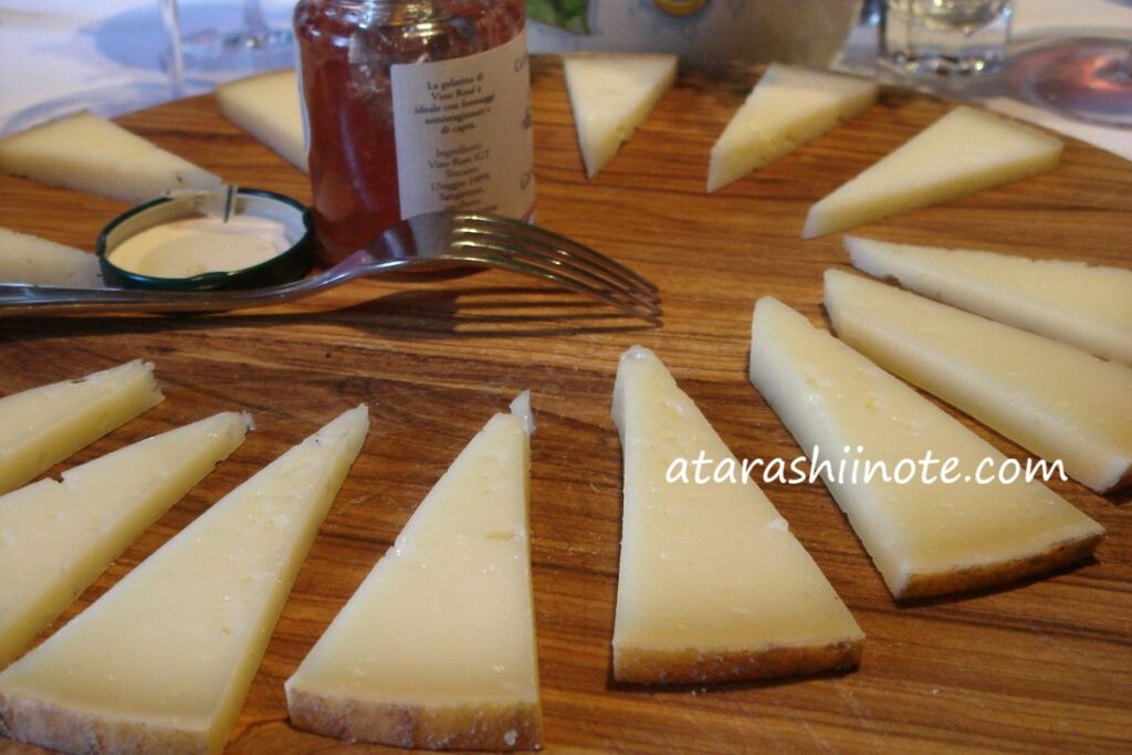 木製のプレートに並ぶ、カットされたペコリーノ